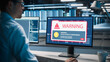 © Gorodenkoff - Male II Specialist in Glasses Faces a Critical Virus Alert on His Desktop Monitor, Reading a Red System Compromised Warning Pop-up While Working in a Modern Data Center Office.