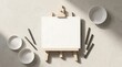 © Fresh Vision - Minimalist easel with a blank canvas displayed on a beige surface with ceramic bowls and chopsticks for an artistic creative concept overhead flat lay view
