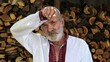 © ExpressVectors - Senior ukrainian man in vyshyvanka standing after hard work near woodshed. Elder tired male resting after hard job near firewood. Concept of national identity and independence. Close up