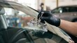 © SimpleDesignStudio - Professional technician repairing a cracked car windshield using a bridge tool in an auto repair shop