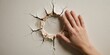 © MT - A young adult female hand touching a large hole in a drywall with cracks representing frustration and anger