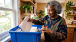 © Mateus - Elderly African American woman sorting mail and documents in a blue bin at home