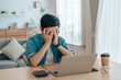 © Monster Ztudio - Asian man are stressed, pain in their eyes, working on laptop in living room at home