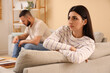 © Pixel-Shot - Upset young woman with her husband sitting on grey sofas at home
