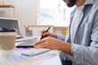 © Pixel-Shot - Male interior designer working at table in office, closeup