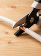 © Wild Creative Hub - Close-Up View of Heavy Duty Cable Sheath Cutter Snipping Insulation Off Thick Copper Wire Cable on Wooden Table Surface