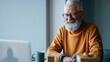 © Anastasiya Marchenko - Smiling elderly man using laptop indoors