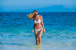 © yellowj - Beautiful young woman in colorful striped bikini on a tropical beach