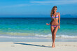 © yellowj - Beautiful young woman in colorful striped bikini on a tropical beach