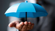 © Nick Freund - Männliche Hand hält blauen Schutzschirm schwebend in dunkler Umgebung