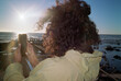 © Tlotliso Mapana/Stocksy - Woman with curly hair taking photos
