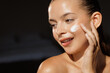 © st.kolesnikov - Young Woman Applying Cream for Radiant Skin