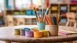 © Tanvir - Colorful art supplies arranged on a wooden table in a classroom. Ideal for creative education and school projects.
