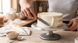 © Andres Mejia - Baker frosting a cake with buttercream icing