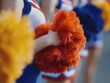 © lolya1988 - Cheerleader holding an orange pom pom during a performance, actively supporting a sports team and generating enthusiasm for school spirit