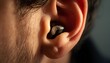 © vionaang - Close-up of a person's ear with a small, discreet earbud inserted into the canal