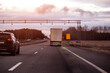 © HENADZY - An SUV and a truck drive on a highway under a cloudy sky, illustrating road transport infrastructure, a toll road money frame. Copy space for text