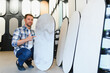 © Serhii - Man selecting decorative interior plaster samples for home renovation