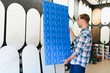 © Serhii - Man choosing decorative wall panel in interior design studio