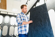 © Serhii - Man examining decorative plaster sample in studio
