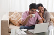 © IndiaPix - Young smiling couple looking at laptop together