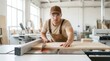 © tanin - Young carpenter using a circular saw to cut a piece of wood in a furniture factory