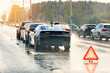 © Tricky Shark - Multi vehicle car accident on wet highway during rain with red emergency warning triangle placed on road. Chain reaction car crash on wet highway during rainy weather. Major multi vehicle pile-up