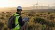 © 19.911a Digital - Specialist overseeing renewable energy operations, utilizing a digital tablet to monitor environmental conditions and collect data at a modern wind farm