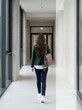 © iz_zi - Professional woman walking through modern office corridor