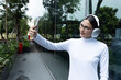 © Rafael - Horizontal shot of a modern Latina woman wearing glasses and headphones, taking a selfie outside a glass building.