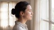 © Giga - Contemplative young woman with hair bun looking out window with thoughtful woman profile profile gazing natural light