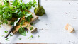 © J.Rynio PHOTOGRAPHY/Stocksy - Fresh pesto preparation on a wooden cutting board with herbs