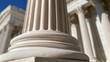 © il - Close-up of a fluted marble column base against a bright blue sky