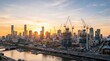 © UnPhouvith - A vibrant cityscape at sunrise dominates the frame, showcasing a modern skyline with numerous construction cranes actively building new skyscrapers.