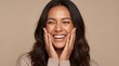 © Eka - Beautifully radiant woman with hands on her cheeks laughing and smiling with eyes closed against a plain background