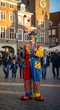 © Gunawan - Colorful clowns performing in historic town square.