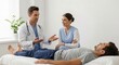 © Lam - Doctor and nurse consulting with a patient on a medical bed in a brightly lit examination room