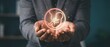 © Mariya Sorvacheva - Hands of a male individual holding a glowing illustration of a fetus in a circular outline, symbolizing fertility treatment and artificial insemination concepts
