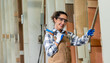 © BESTIMAGE - One Strong confident young aged woman carpenter smiling look at camera in workshop. Latin female carpenter entrepreneur working with wood plank furniture tool in workbench shop carpentry