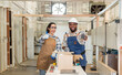 © BESTIMAGE - Two confident carpenter teamwork coworker colleague showing thumbs up look at camera and smile in workshop. man and women worker carpenter entrepreneur stand working in workbench shop carpentry