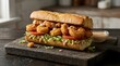 © Infinite Frame - A delicious submarine sandwich with crispy fried shrimp lettuce and tomato on a dark stone board. shrimp po boy