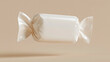 © mushfiqhossein - A glossy white rectangular candy or product wrapper, tied at both ends, floats cleanly on a beige background. Ideal for showcasing confectionery, packaging, or sweet indulgence.