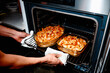 © Juan Moyano/Stocksy - a man removing baked macaroni and cheese from the oven