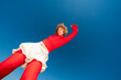© Basil Pind/Stocksy - Woman posing in red and white outfit against blue sky
