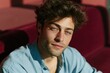 © Iryna - Closeup warm sunlight portrait of relaxed young man with blue eyes on velvet sofa for casual lifestyle headshot background