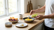 © MDJAHIR - A man preparing a healthy breakfast with fresh fruit and eggs in a bright modern kitchen