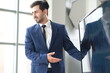 © unikyluckk - Portrait of positive business man looking at camera in modern office. Business consultant meeting is discussing financial situation, analyzing budget and planning business investments. Business