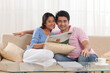 © IndiaPix - Portrait of young couple smiling with newspaper