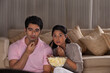 © IndiaPix - Young scared couple watching movie together at home
