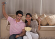 © IndiaPix - Happy young couple enjoying while watching TV at home